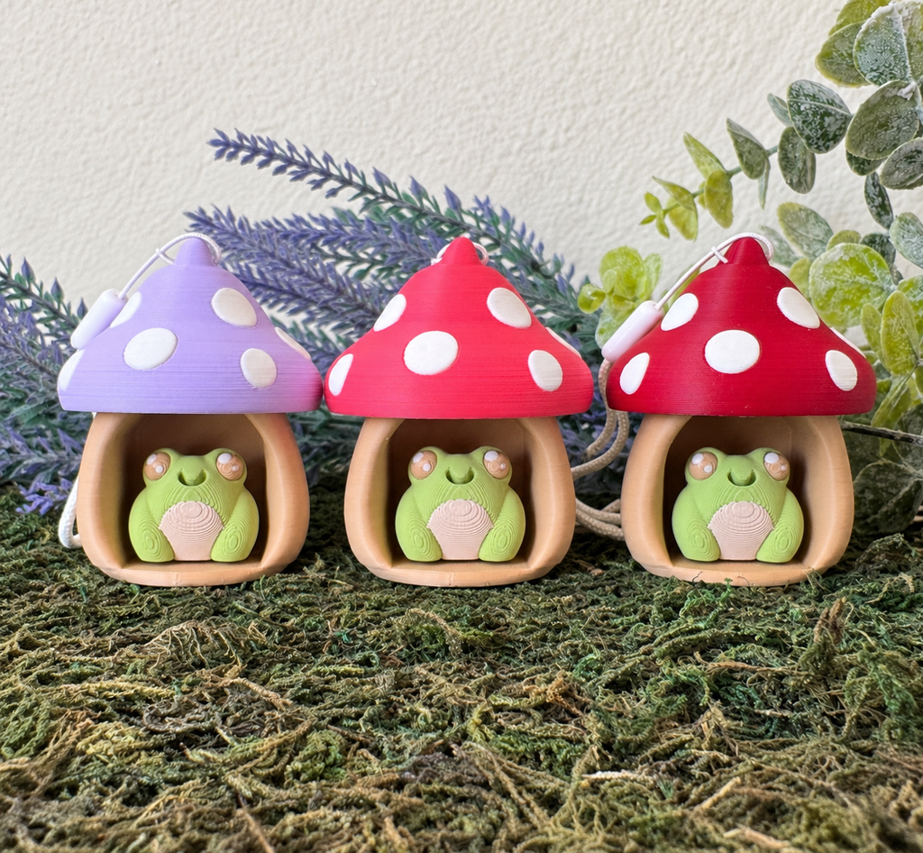 Three mushroom frog keychains in lavender, red, and deep red
